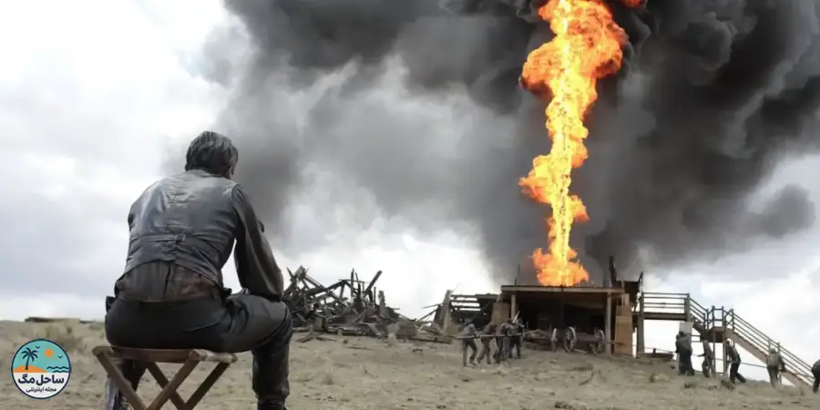 Daniel Day-Lewis sitting with his back to the camera seeing an explosion in There Will Be Blood